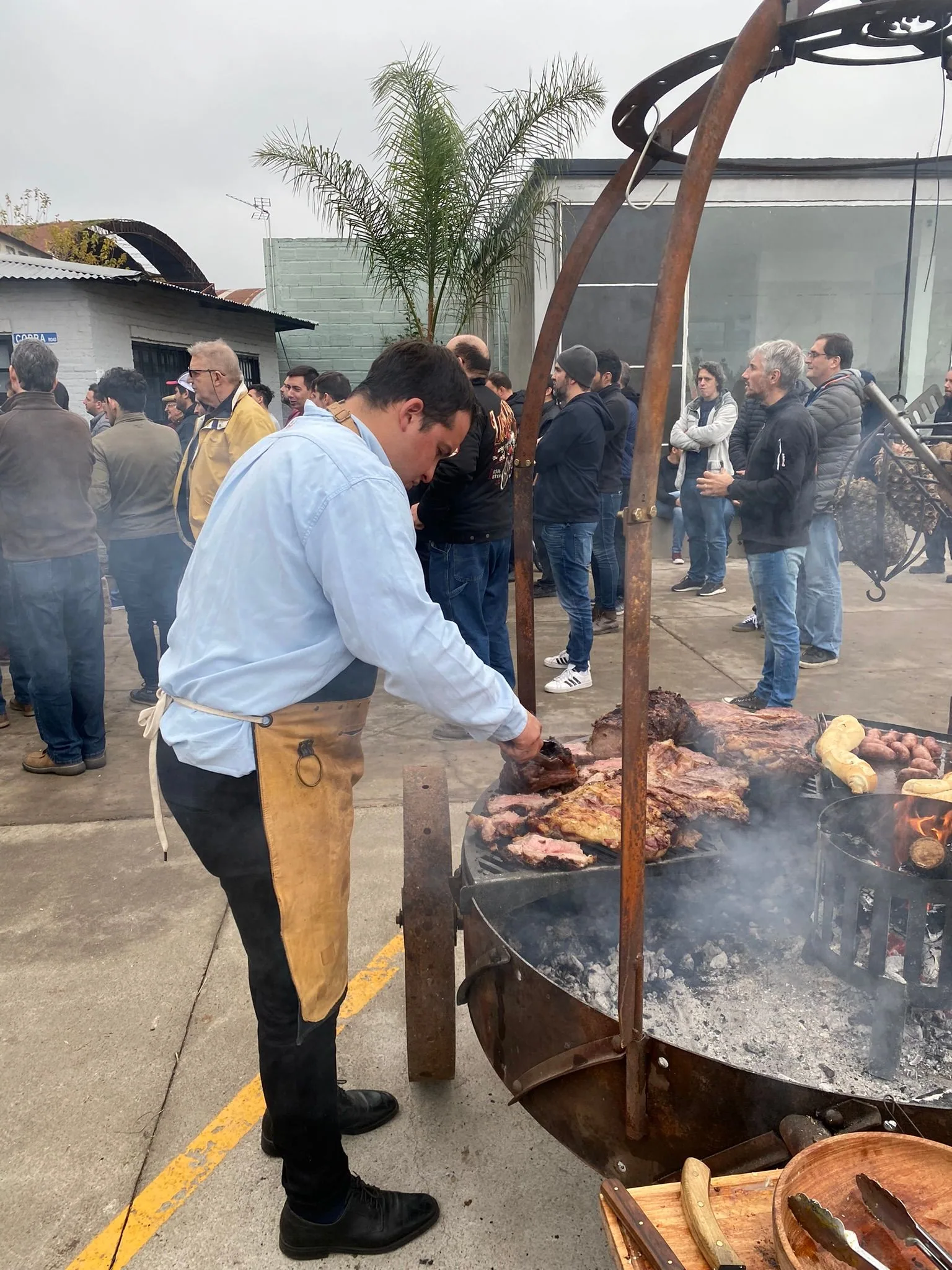 A chef cooking over the fire for a crowd at an outdoor event