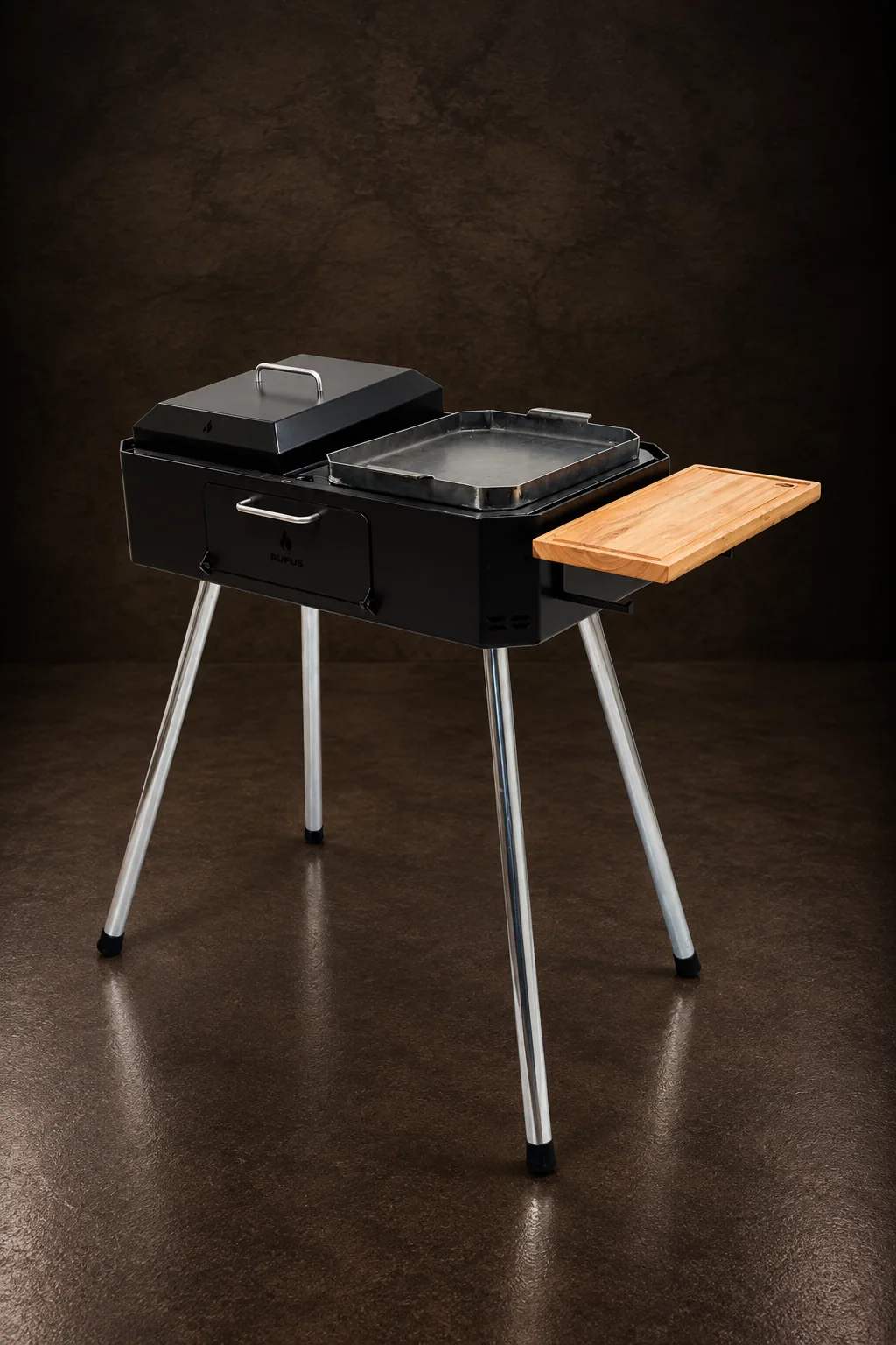 The Austral 75 charcoal grill on its zinc-plated legs, on dark stone