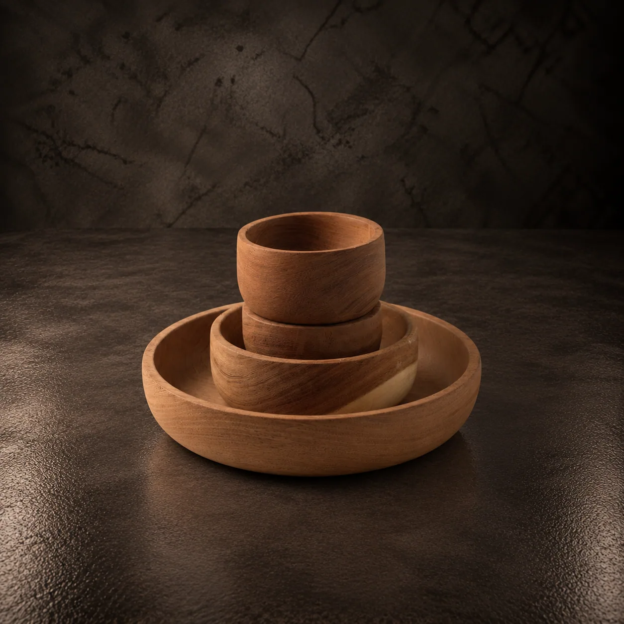 Turned carob wood bowls and dish, on dark stone