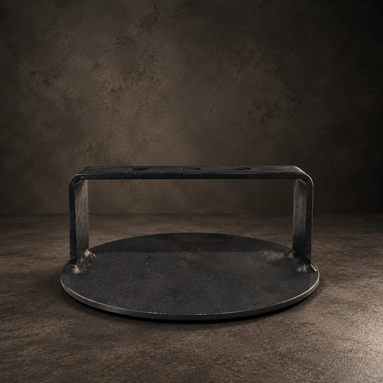 The handcrafted steel burger smasher, on dark stone