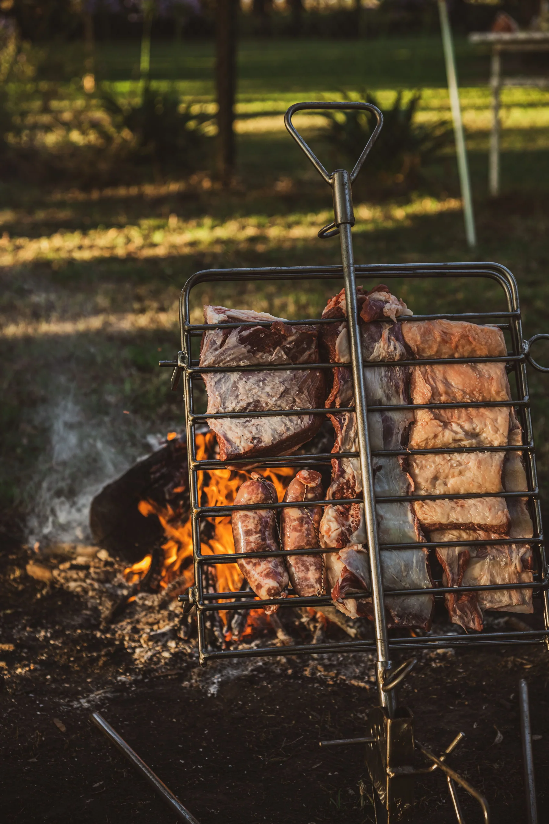 Sostiene small roaster with ribs and sausages over the fire