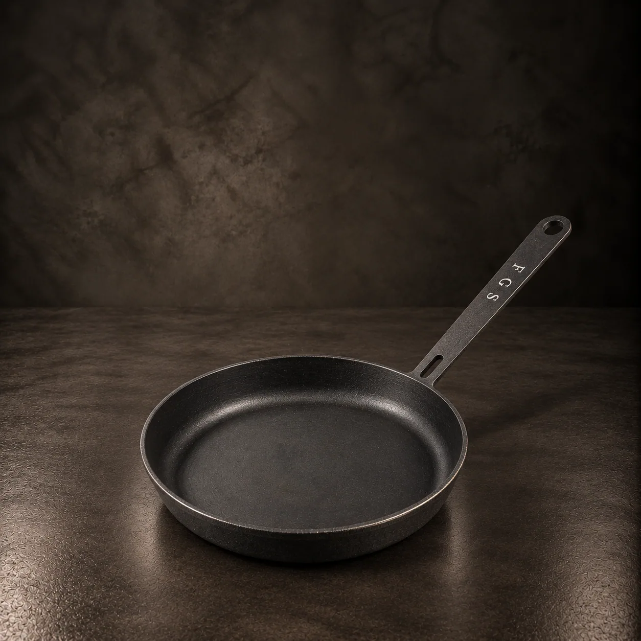 The riveted steel pan, on dark stone
