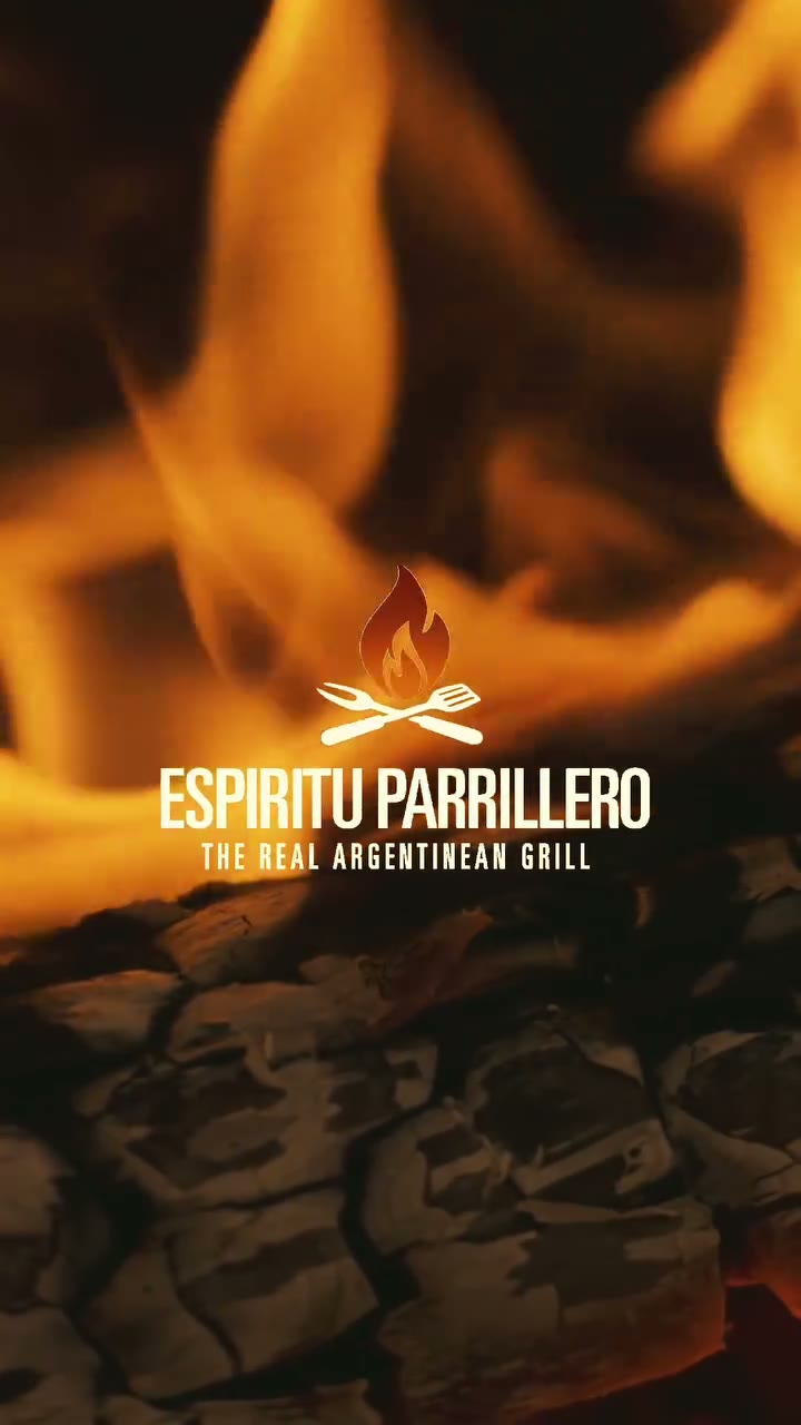The Espíritu Parrillero mark and wordmark over a live flame and a bed of embers, the closing frame of the company film